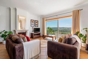 a living room with two couches and a large window at SUNSET Apartment in Amoreira