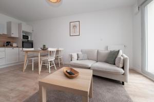 a living room with a couch and a table at La belle étoile - 4 pers - balcon in Vannes