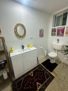 a bathroom with a sink and a toilet and a mirror at Bellingen Disco Studio in Gleniffer +17 photos