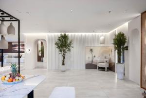 a living room with white furniture and plants at Hima Al Tahliyah Serviced Apartments in Jeddah +29 photos