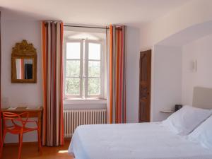 a bedroom with a bed and a desk and a window at Hôtel La Figuière in Saint-Tropez +58 photos