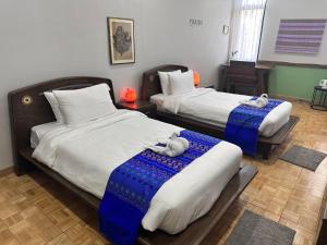 a hotel room with two beds with towels on them at PhuKasa Valley Maesot -Wellness Resort in Ban Mae Kasa