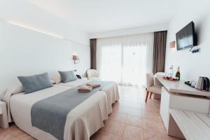 a hotel room with a large bed and a television at Sagitario Princesa Playa in Son Xoriguer +51 photos