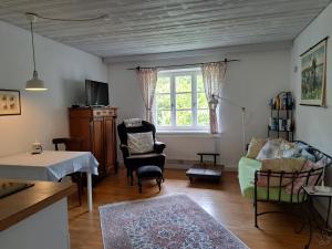 a living room with a couch and chairs and a window at Ferienwohnungen im Lüftlmalereck, Mussldomahaus in Oberammergau