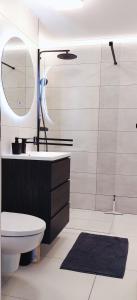 a bathroom with a sink and a toilet and a mirror at KM Art Apartman in Sfântu-Gheorghe