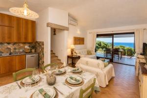 a kitchen and a living room with a table and chairs at Villa Turchese - Key to Villas in Costa Paradiso