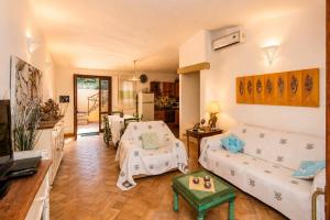 a living room with a couch and a table at Villa Turchese - Key to Villas in Costa Paradiso