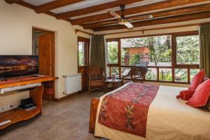 a bedroom with a bed and a large window at Hostería y Cabañas Altamar De Las Pampas in Mar de las Pampas