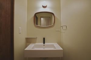 a bathroom with a white sink and a mirror at sunroom Hotel,Cafe,Bar in Miyazaki +47 photos