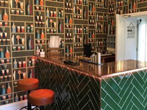 a bar in a room with a wall of vases at Baie Mooar House, Boutique B&B in Ramsey