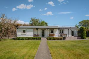a house with a green lawn in front of it at Cottages On St Andrews in Havelock North