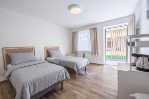 a bedroom with two beds and a large window at DANUBike in Dobrohošť