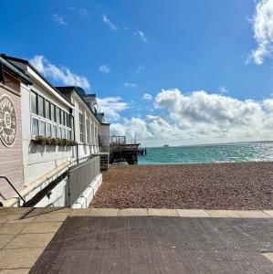 a building on a beach next to the ocean at Garden Apartment by the Pier in Portsmouth