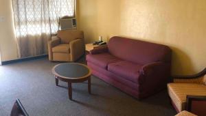 a living room with a couch and a chair at M Star Hotel Mansfield in Mansfield +23 photos