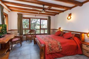 a bedroom with a bed with a red comforter at Hostería y Cabañas Altamar De Las Pampas in Mar de las Pampas +61 photos