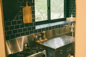 a kitchen with a stainless steel sink and a window at 天然温泉が満喫できる一棟貸宿 little villa 柊日 in Azumino +28 photos
