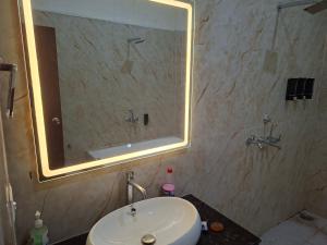 a bathroom with a sink and a large mirror at Prem niwas in Kakarmatha