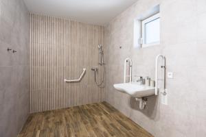 a bathroom with a sink and a shower and a sink at DANUBike in Dobrohošť +19 photos