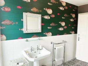 a bathroom with a sink and a mirror at Baie Mooar House, Boutique B&B in Ramsey +32 photos