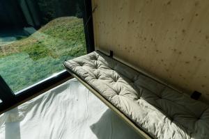 a couch sitting in a room with a window at Unbound Hütte Lenzerheide in Tiefencastel