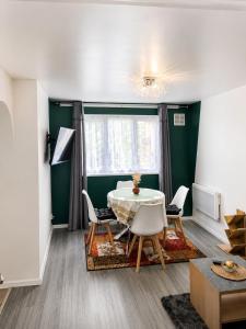 a dining room with a table and chairs at The Express Apartment in Goodmayes