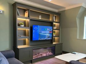 a living room with a flat screen tv and a fish tank at Killarney Flesk River Apartments in Killarney