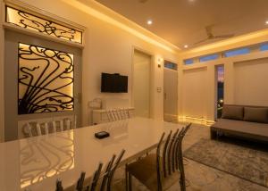 a dining room with a white table and chairs at The Collectors Loft in Jaipur