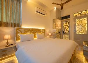 a bedroom with a large white bed and a window at The Collectors Loft in Jaipur