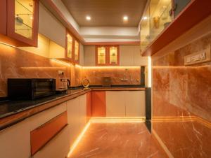 a kitchen with white cabinets and a microwave at The Collectors Loft in Jaipur