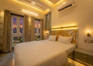 a bedroom with a large white bed and a window at The Collectors Loft in Jaipur