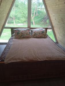 a bed in a room with a window at A-frame family in Prokurava