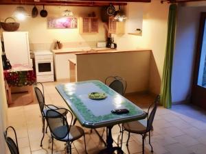 a kitchen with a table and chairs in a room at La Fée Du Val - Gite En Ardèche in Rosières