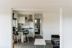 a kitchen and living room with a couch and a table at Cottages On St Andrews in Havelock North