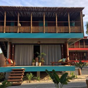 a resort with a blue building with a balcony at Pousada Vila Gostoso in São Miguel do Gostoso