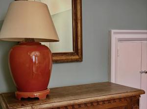 a red vase sitting on a table with a lamp at Donna Lucia Apulian Experience in Ruvo di Puglia +2 photos