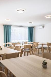 a dining room with tables and chairs and a window at DANUBike in Dobrohošť