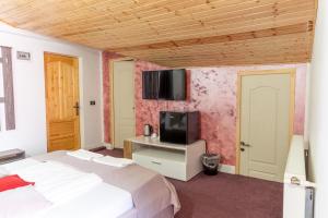 a bedroom with a bed and a tv on the wall at Hotel Boutique Casa Vermont in Bucharest