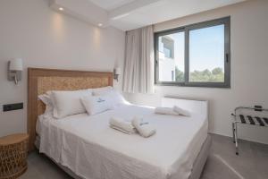 a bedroom with a white bed with towels on it at Milva Mare Luxury Apartments in Kos