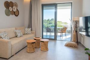 a living room with a couch and two stools at Milva Mare Luxury Apartments in Kos