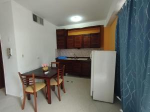 a kitchen with a table and a white refrigerator at Apartamento en puerta del sol 17 in La Loma