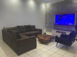 a living room with a couch and a tv at Plaza Hotel in Itaituba