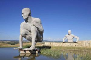a statue of a man sitting on a skateboard in the water at Pura Apartment Hill View Stay near Peccioli & Lajatico in Palaia +14 photos