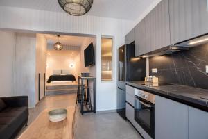 eine Küche und ein Wohnzimmer mit Sofa und Tisch in der Unterkunft Næxon in Vívlos