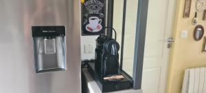 a refrigerator with a drink dispenser on the door at Maison Acacias Le Mans in Le Mans