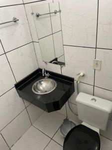 a small bathroom with a sink and a toilet at Plaza Hotel in Itaituba