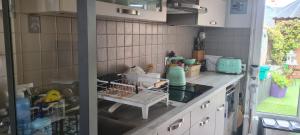 a kitchen with a dish rack on the counter at Maison Acacias Le Mans in Le Mans