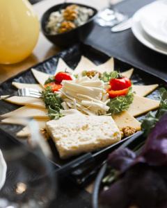 a plate of food with cheese and vegetables on a table at GetAp Resort Arzni in Arzni