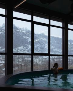 a woman in a bath tub in a room with a window at GetAp Resort Arzni in Arzni