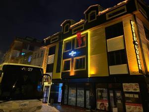 a bus parked in front of a building at night at David Moser 1878 Oteli in Kars +11 photos