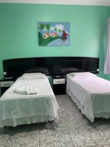 two beds sitting next to each other in a room at Plaza Hotel in Itaituba